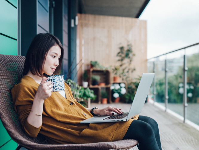Lady sitting at the balcony with her laptop